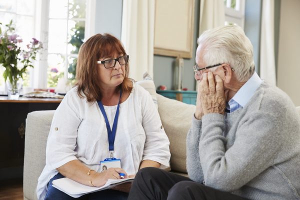 Support Worker Visits Senior Man Suffering With Depression
